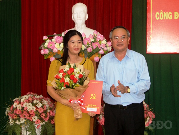 Trưởng ban Tổ chức Tỉnh ủy Nguyễn Giờ trao quyết định, tặng hoa chúc mừng đồng chí Nguyễn Đặng Thị Thu Hòa.
